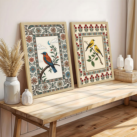 Two framed artworks of birds on a wooden console table with decorative vases.